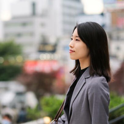 Profile view of Asian young businesswoman on street in downtown